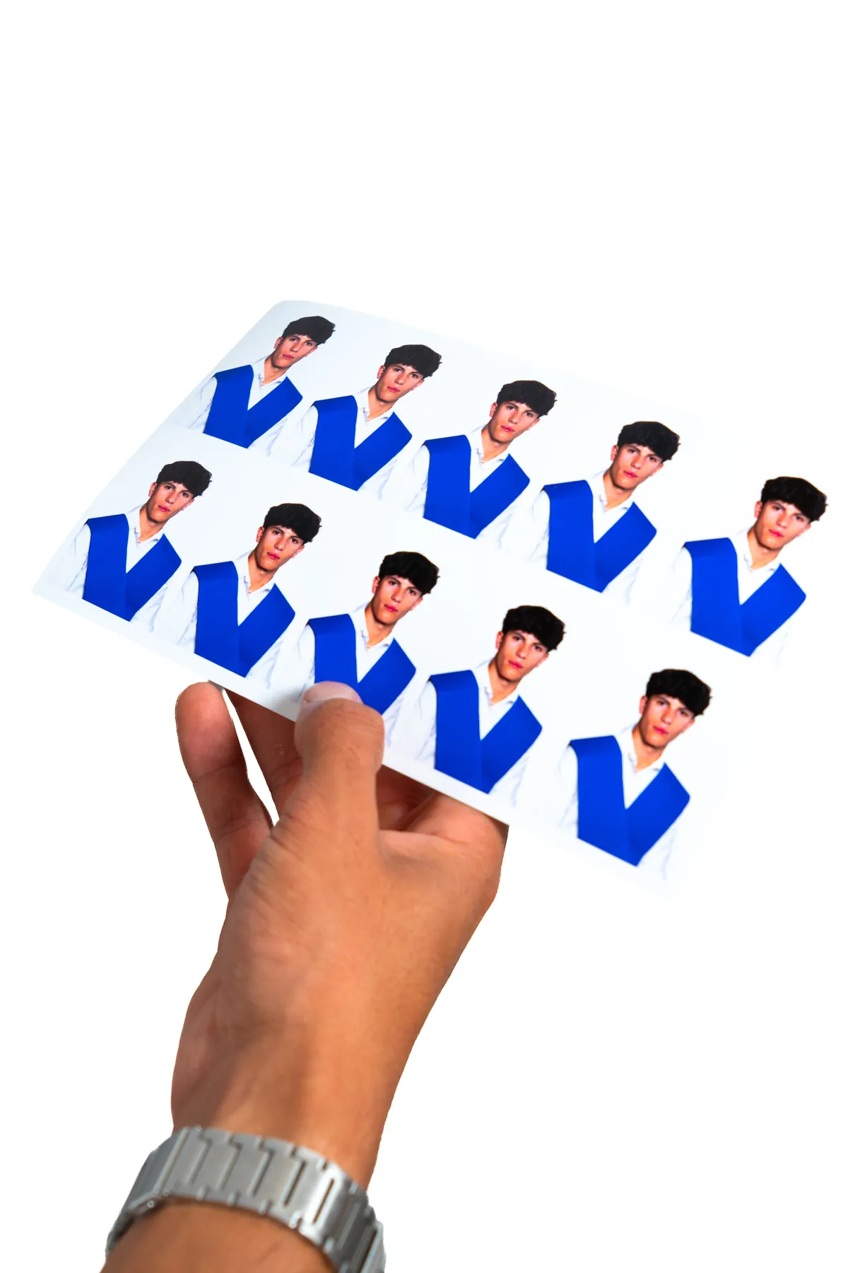 Mano sosteniendo una hoja de fotos tamaño carnet recién impresas