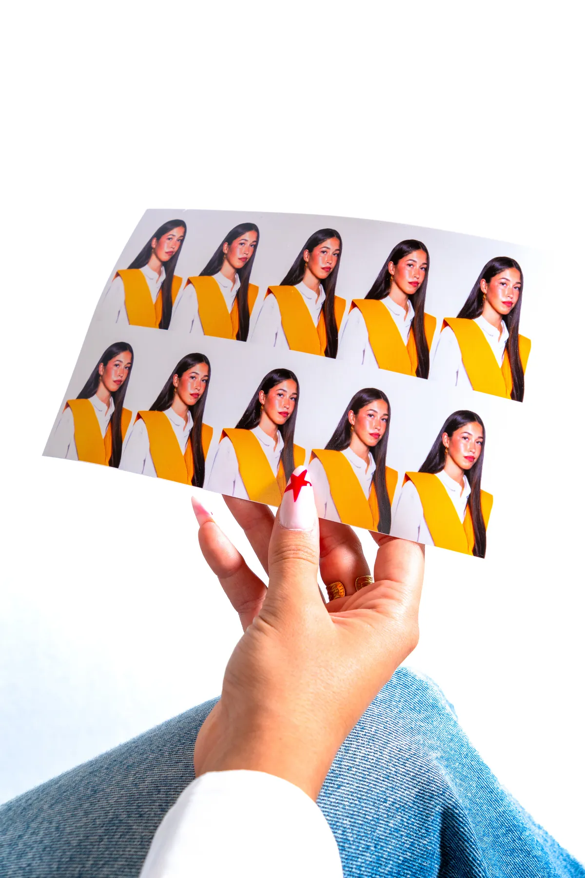 Hoja de retratos tamaño carnet sostenida en la mano